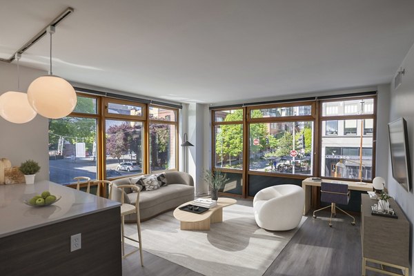 Modern living room with sleek decor and large windows at The Goodwin Apartments