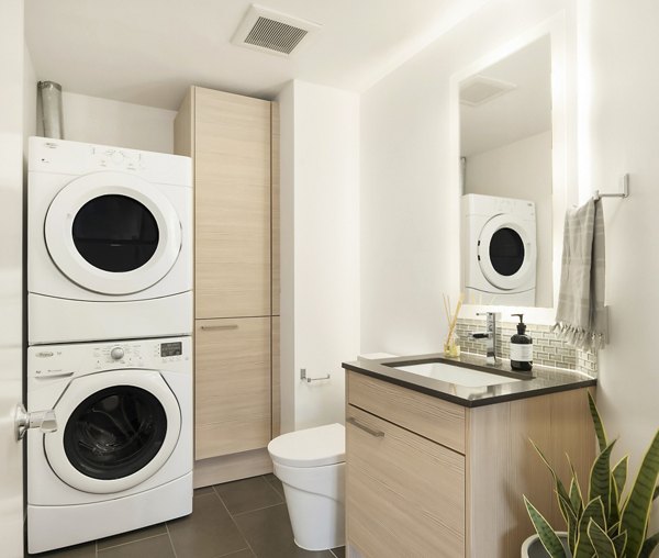 Bath and laundry room with modern fixtures at The Goodwin Apartments