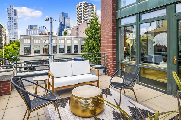 Modern outdoor patio at The Goodwin Apartments with lounge seating and greenery