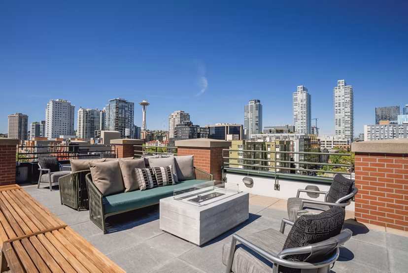 Outdoor patio with cozy fire pit at The Goodwin Apartments, ideal for relaxation in a luxury setting