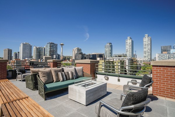 Outdoor patio with cozy fire pit at The Goodwin Apartments, ideal for relaxation in a luxury setting