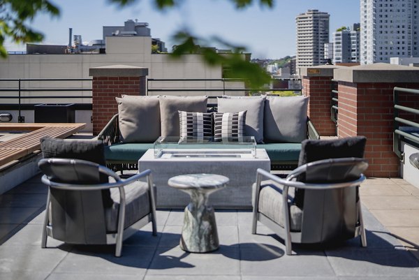 Cozy fire pit on a stylish patio at The Goodwin Apartments, perfect for outdoor gatherings and relaxation