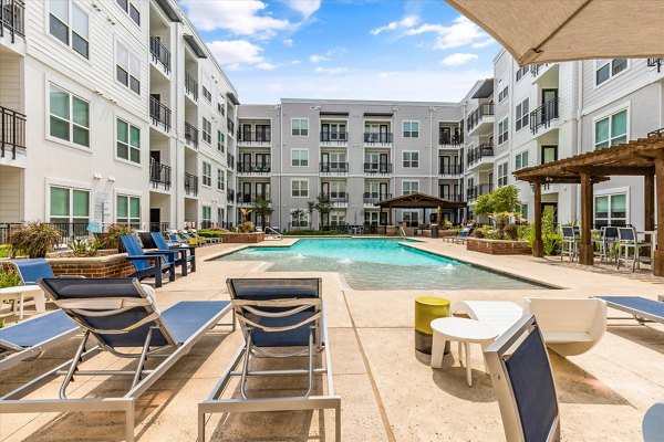 Resort-style pool with lounge chairs at Lakeside Urban Center Apartments in a luxury setting