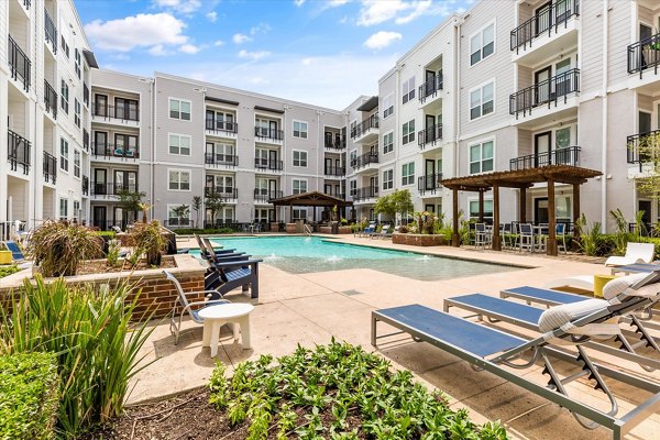 Resort-style pool with sun loungers at Lakeside Urban Center Apartments, offering luxury living and leisure amenities