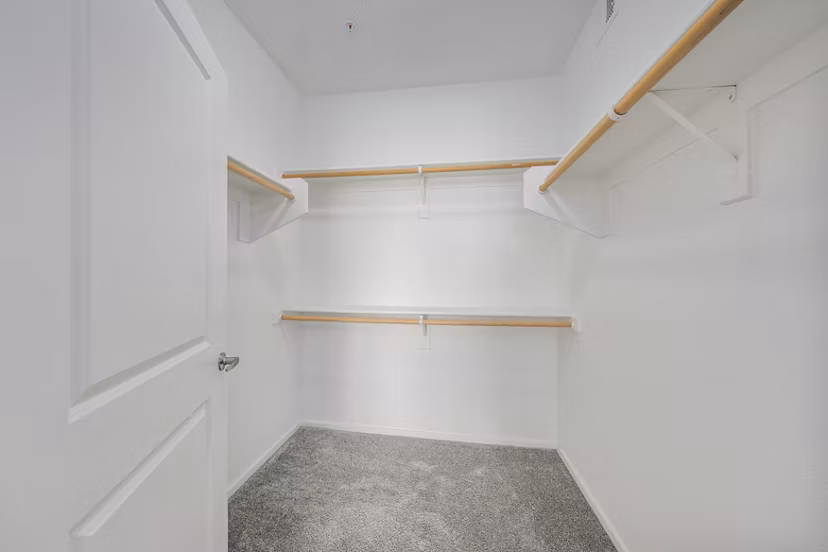 Spacious closet with built-in shelving in the master bedroom at Indigo Apartments
