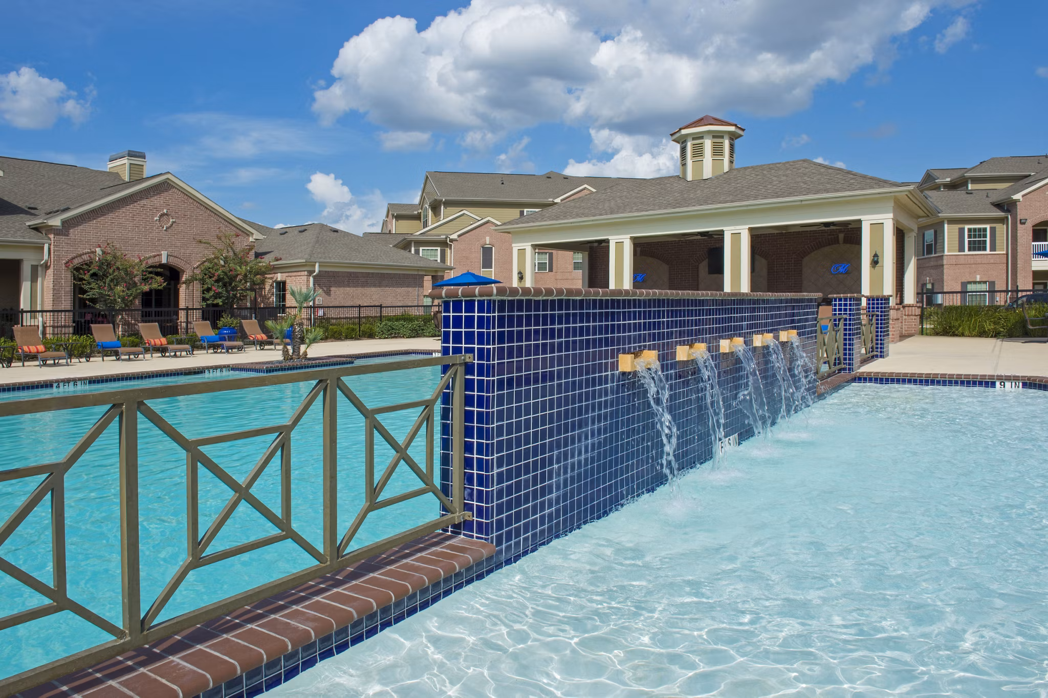 Resort-style swimming pool with lush landscaping at Montage at Cinco Ranch Apartments