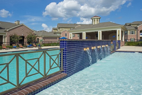 Resort-style swimming pool with lush landscaping at Montage at Cinco Ranch Apartments