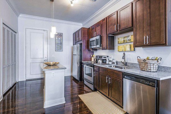 Modern kitchen with sleek countertops and stainless steel appliances at The Four Apartments in a Greystar luxury community