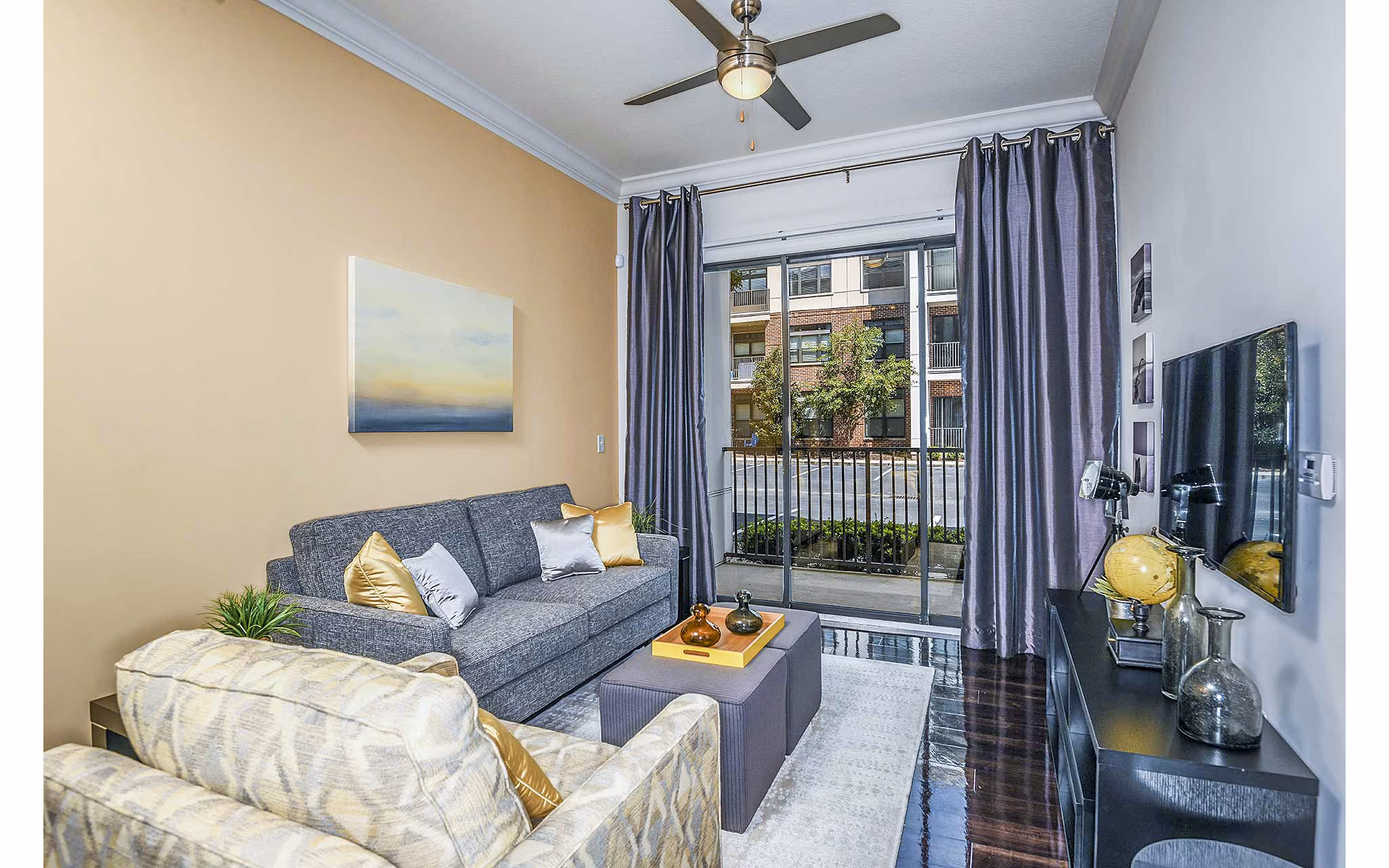Living room featuring modern decor and large windows at The Four Apartments in a luxury community