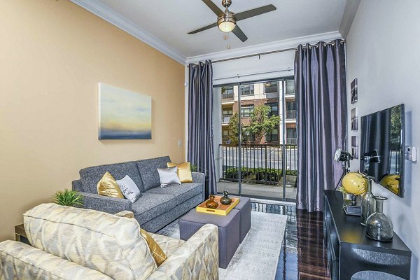 Living room featuring modern decor and large windows at The Four Apartments in a luxury community