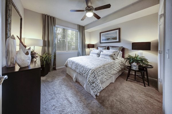 Modern bedroom with elegant decor at 33 West Apartments, featuring plush bedding and ample natural light