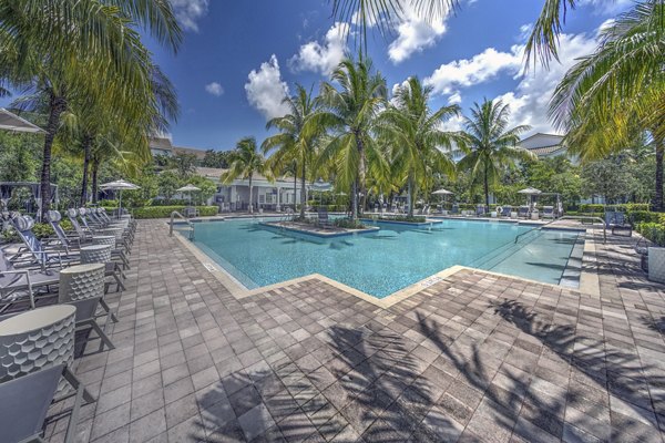 Sparkling outdoor pool at 33 West Apartments with sun loungers and landscaped surroundings, offering a luxurious retreat for residents