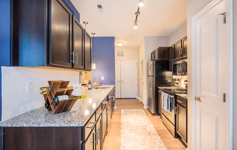 Modern kitchen with stainless steel appliances and granite countertops at Element Carolina Bay Apartments