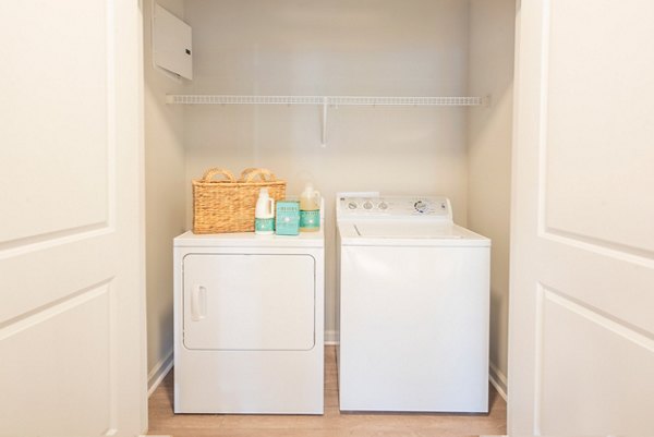 Laundry room with modern appliances at Element Carolina Bay Apartments in Charleston