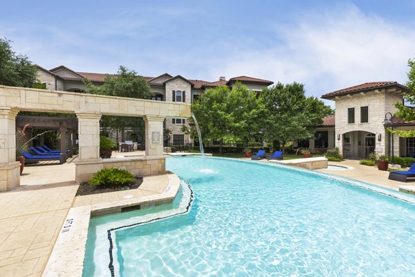 Serene outdoor pool area with lounge chairs at 3500 Westlake Apartments, ideal for relaxation in luxury living