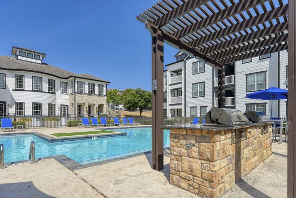 Resort-style pool at Archer Stone Canyon Apartments with comfortable sun loungers and greenery