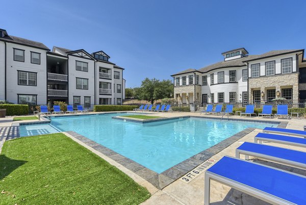 Resort-style pool at Archer Stone Canyon Apartments with lush landscaping