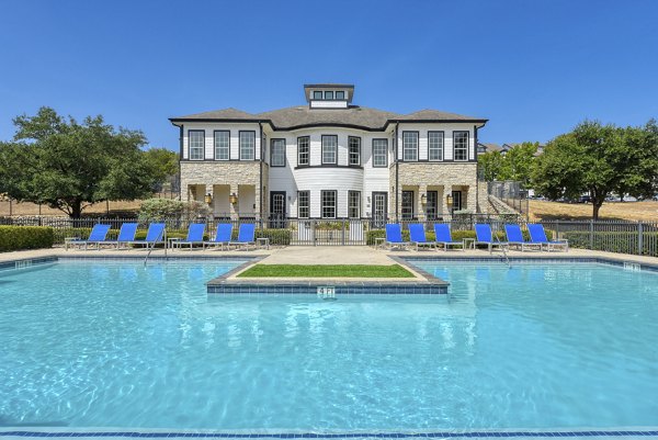 Resort-style pool with lounge chairs at Archer Stone Canyon Apartments, offering a serene retreat for relaxation and leisure