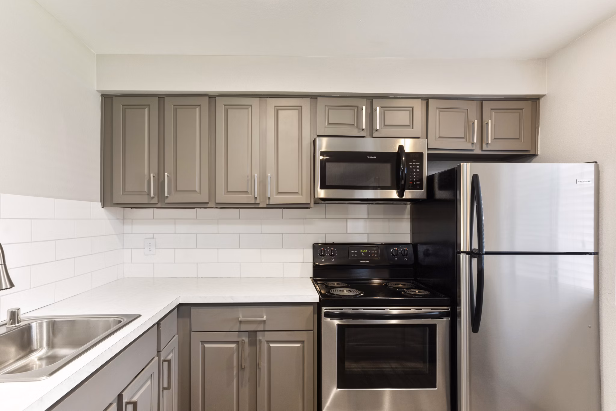 Modern kitchen featuring stainless steel appliances and granite countertops in Highland Park Apartments