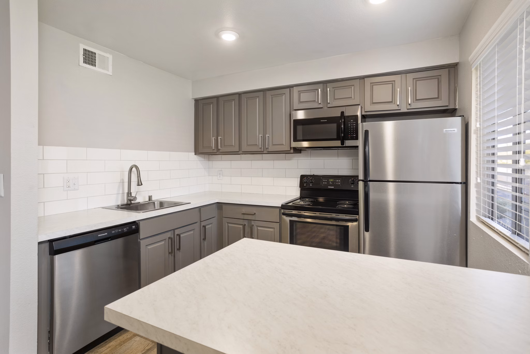 Contemporary kitchen with modern appliances at Highland Park Apartments, featuring sleek countertops and elegant cabinetry