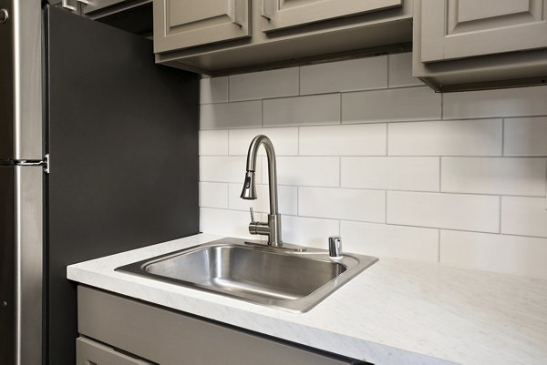 Modern kitchen with stainless steel appliances and granite countertops at Highland Park Apartments