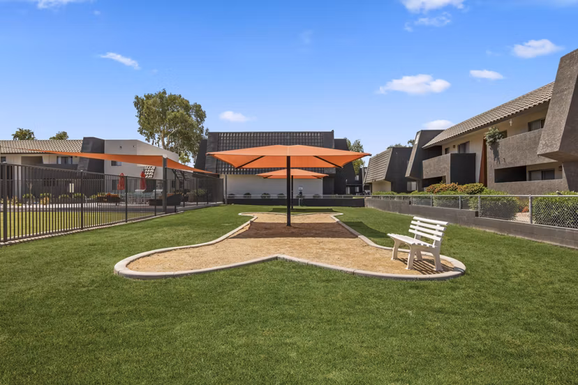Fenced dog park with agility equipment at Highland Park Apartments, ideal for pet owners seeking luxury living spaces