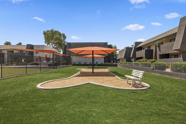 Fenced dog park with agility equipment at Highland Park Apartments, ideal for pet owners seeking luxury living spaces