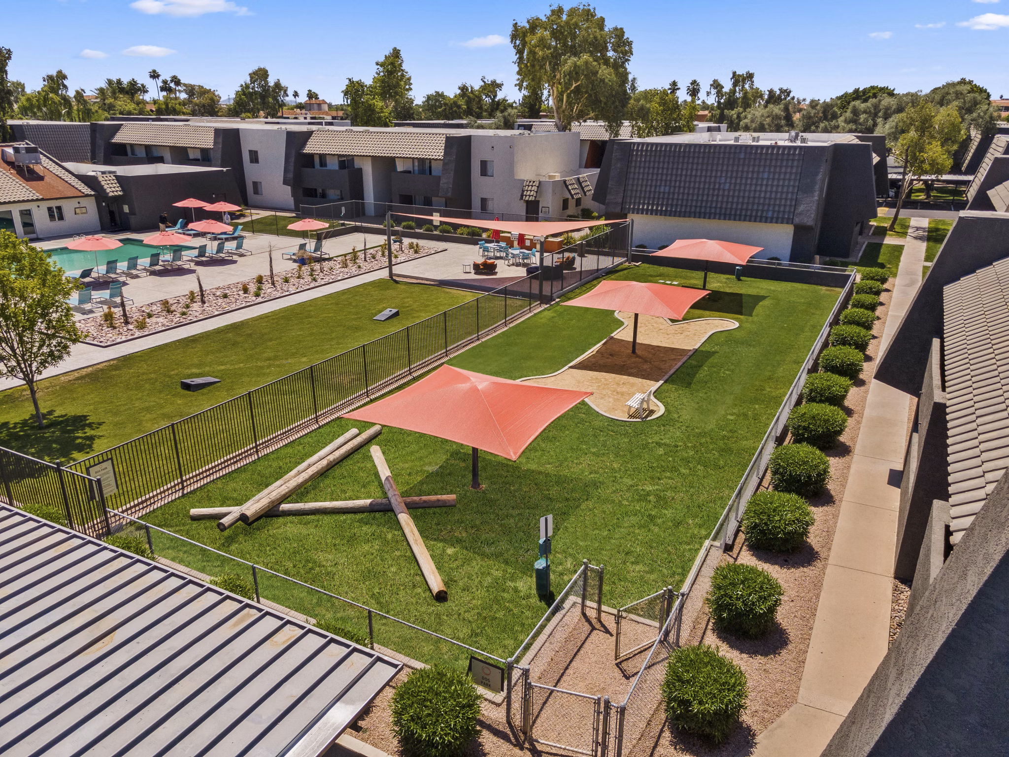 Fenced dog park with agility equipment at Highland Park Apartments