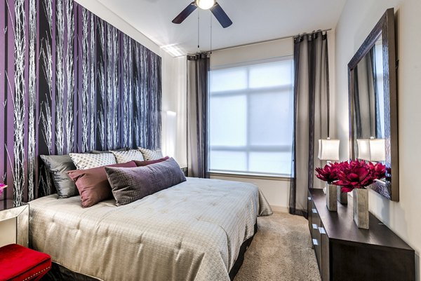 Tranquil bedroom with modern decor and large windows at WaterWall Place Luxury Apartments