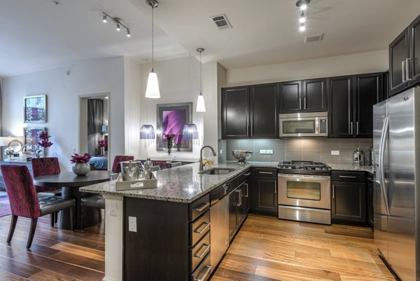 Modern kitchen with stainless steel appliances at WaterWall Place Luxury Apartments