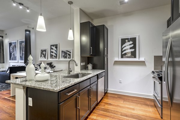 Modern kitchen with stainless steel appliances at WaterWall Place Luxury Apartments
