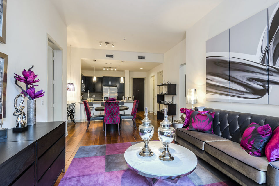 Spacious living room with elegant furnishings and large windows at WaterWall Place Luxury Apartments