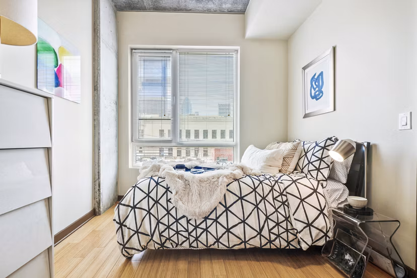 Bedroom with sleek modern furnishings at The Granary Apartments, luxury living by Greystar