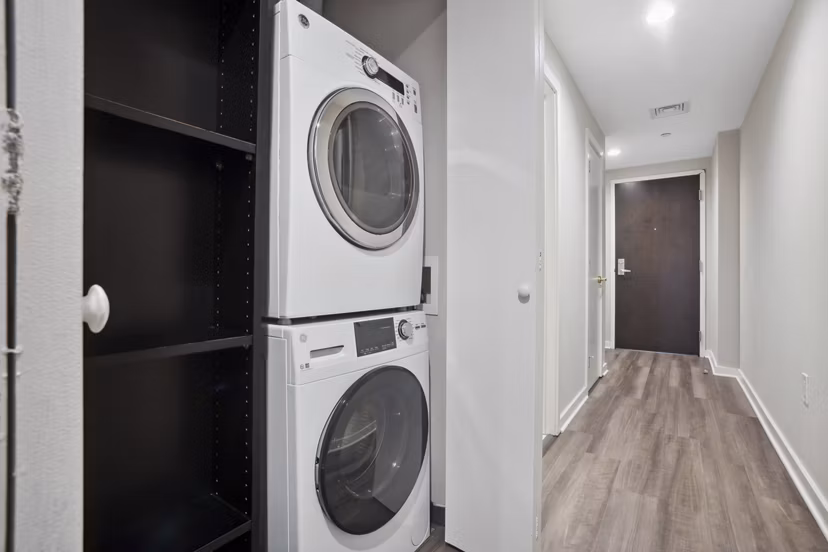 Laundry room featuring modern appliances at Drexler Townhomes, luxury apartments at Holbrook Farms