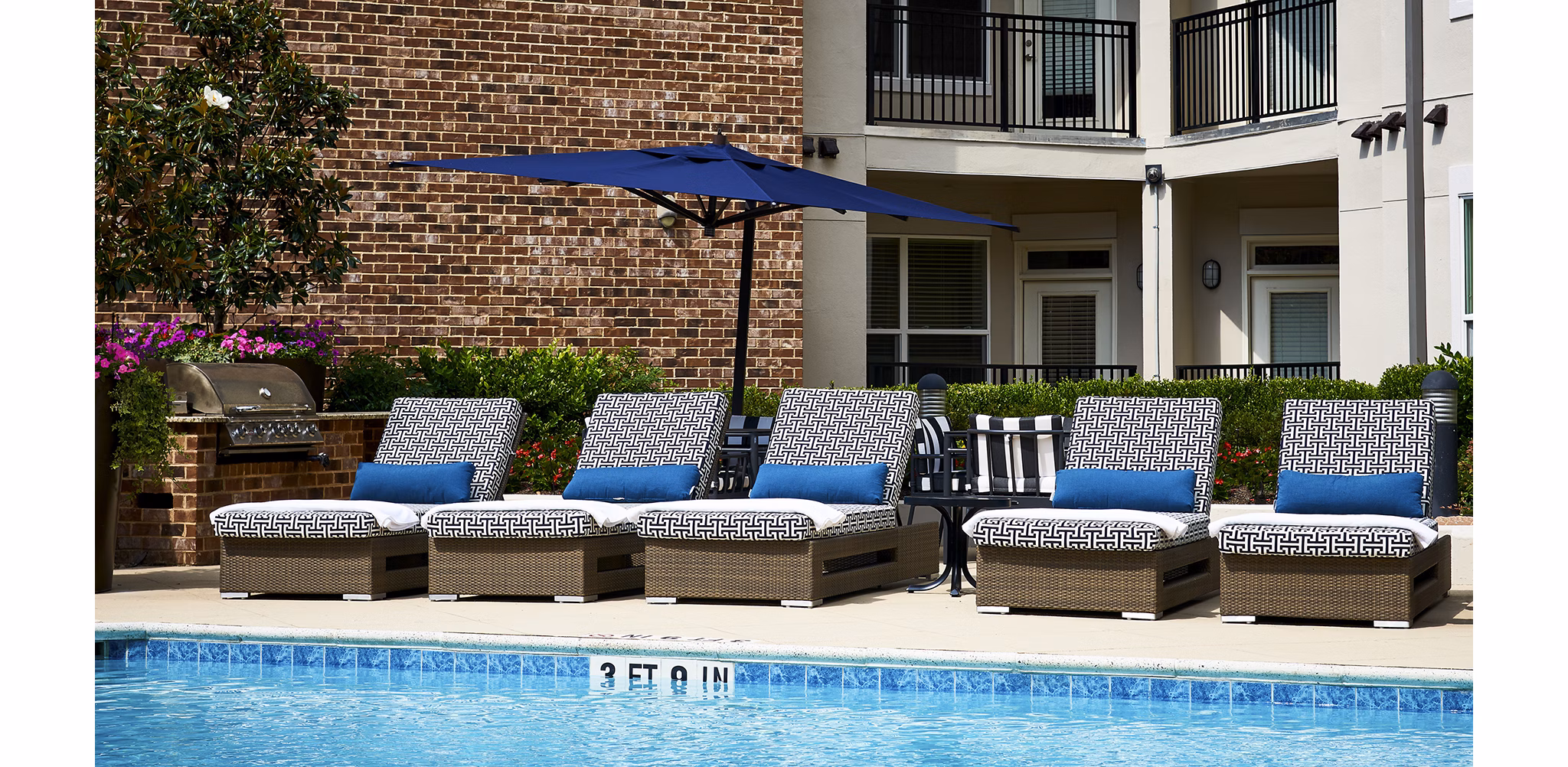 â€œStylish pool surrounded by loungers at Solis SouthPark Apartmentsâ€