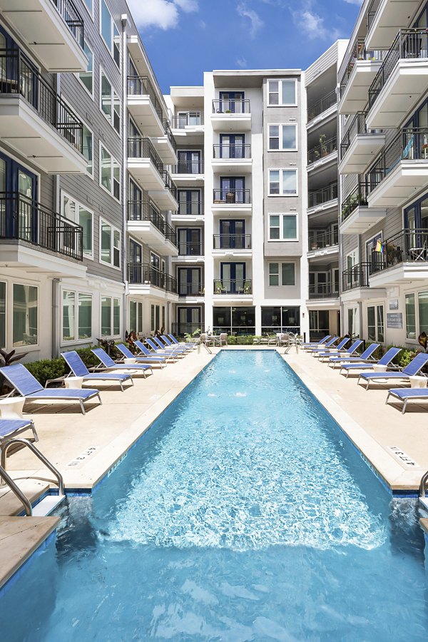 Rooftop pool with lounge chairs and skyline views at Burnet Flats Luxury Apartments