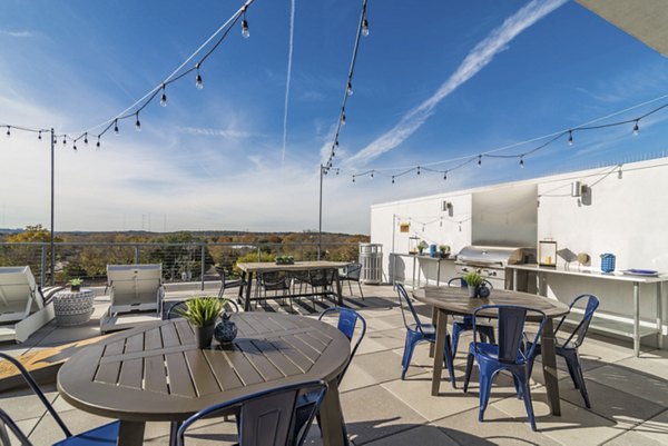 Outdoor grill area surrounded by lush greenery at Burnet Flats Luxury Apartments