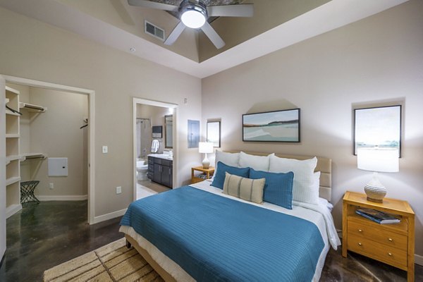 Spacious bedroom with modern decor in Elan Med Center Apartments, featuring luxury finishes and ample natural light