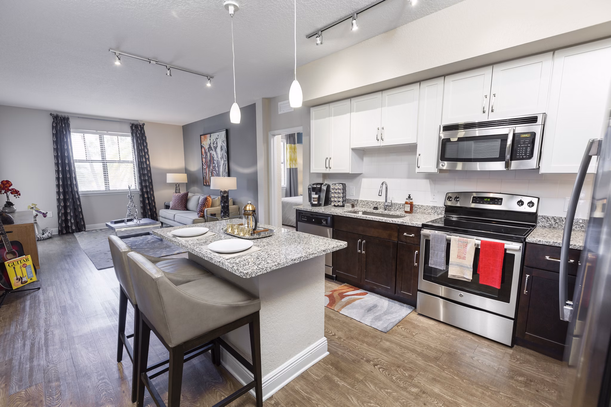 Contemporary kitchen featuring stainless steel appliances and granite countertops in 2 Bayshore Apartments