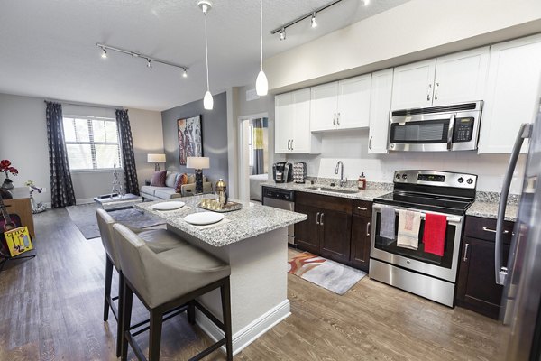Contemporary kitchen featuring stainless steel appliances and granite countertops in 2 Bayshore Apartments