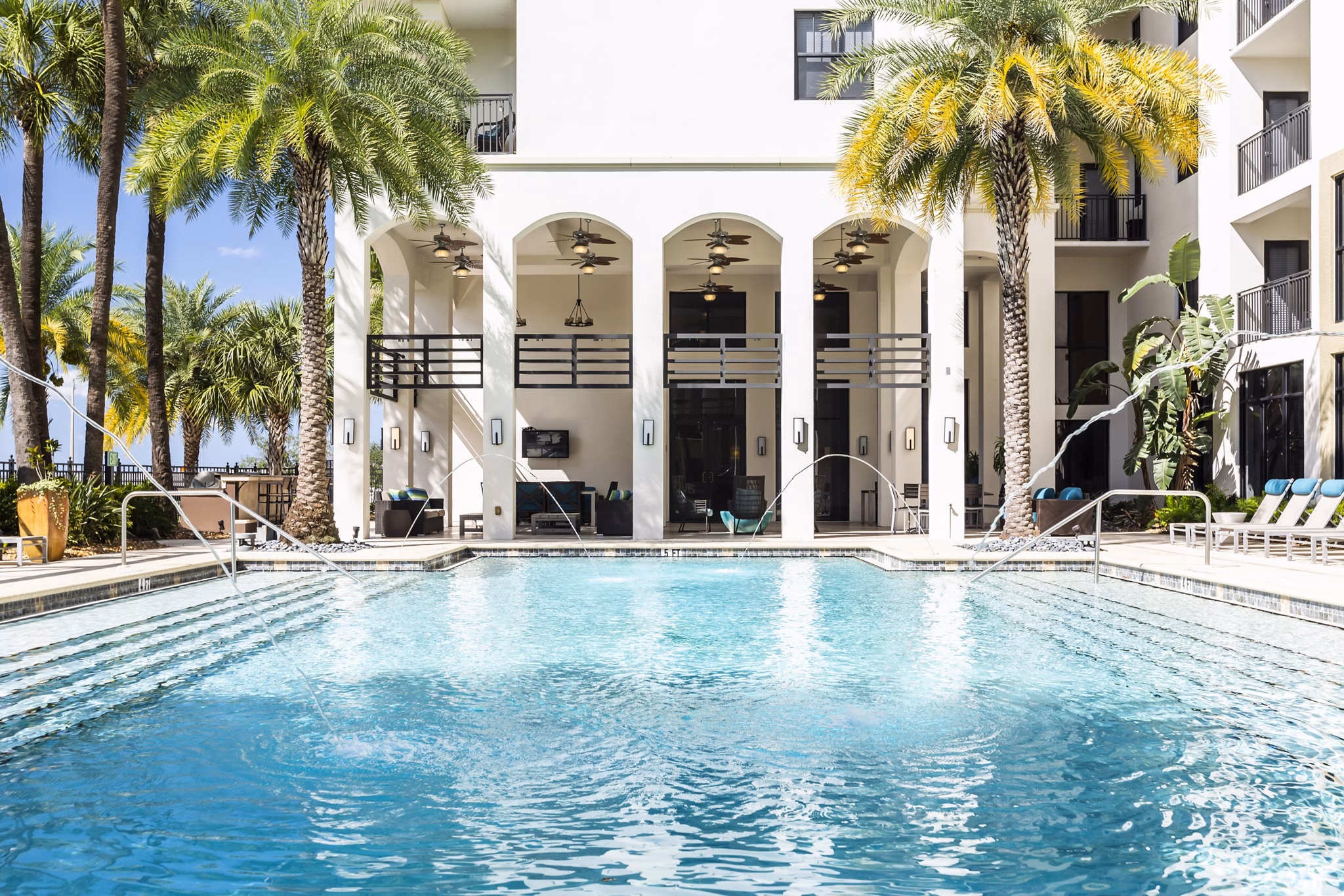 Scenic outdoor pool with lounge chairs at 2 Bayshore Apartments, a luxury community offering upscale waterfront living