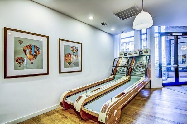 Skee-ball game setup with framed hot air balloon pictures in a vibrant recreational room