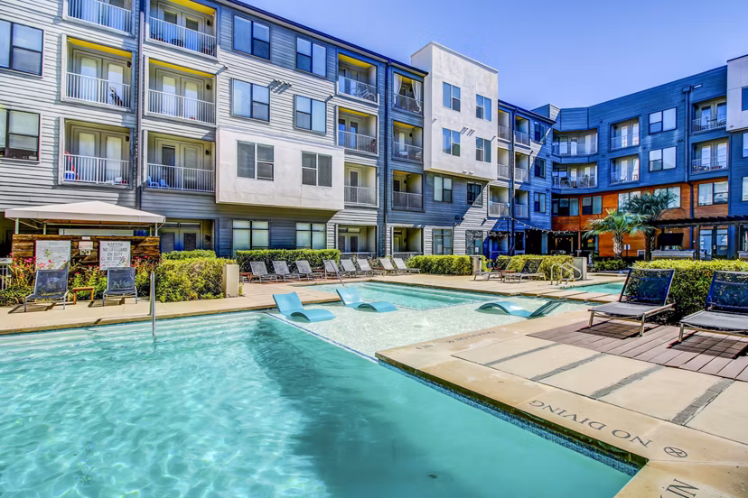 Resort-style pool area with lounging chairs at Elan East Apartments