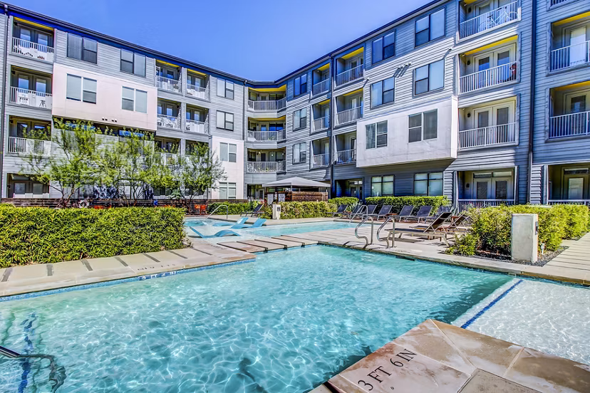 Modern pool with sun loungers at Elan East Apartments, offering luxury outdoor living in a relaxing environment