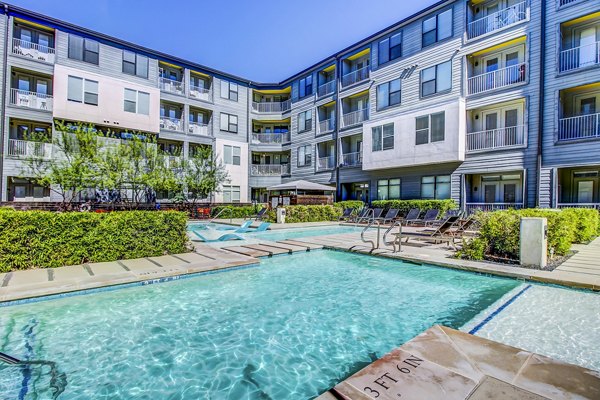 Modern pool with sun loungers at Elan East Apartments, offering luxury outdoor living in a relaxing environment