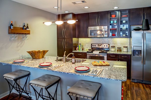 Modern kitchen with sleek appliances and quartz countertops at Coldwater Luxury Apartments