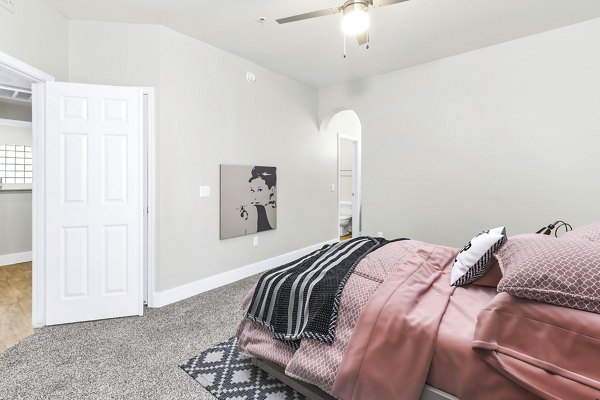 Cozy bedroom featuring stylish decor and large windows at Fountain Palms Apartments