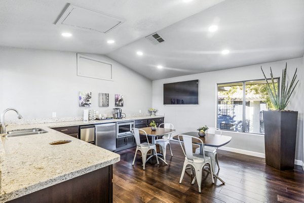 Modern clubhouse kitchen with granite countertops and stainless steel appliances at Fountain Palms Apartments, luxury living space for residents