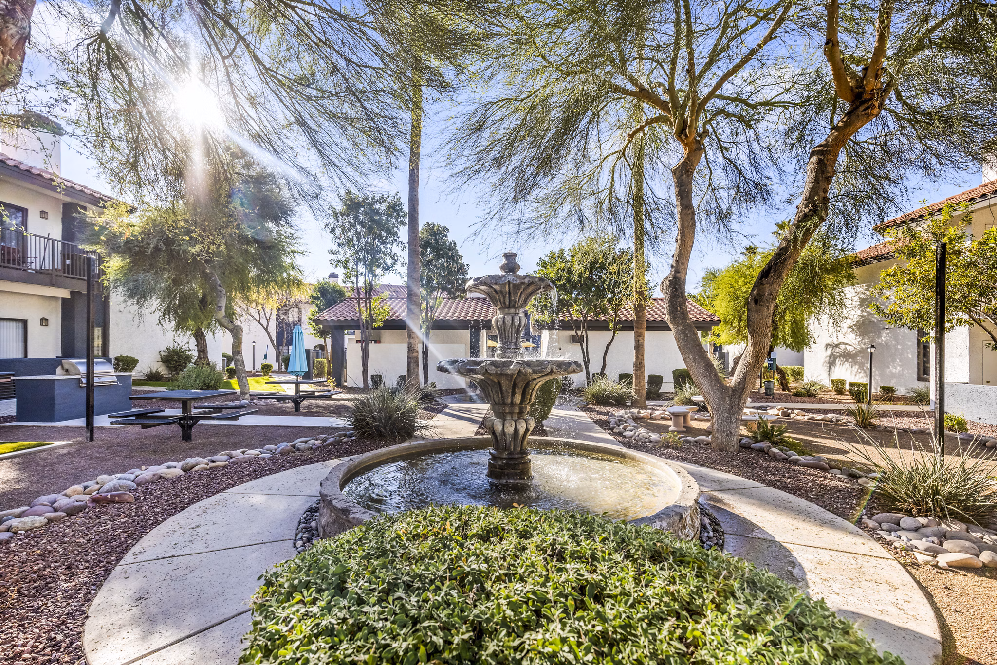 Courtyard with lush landscaping and seating areas at Fountain Palms Apartments