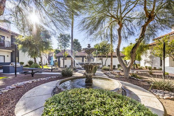 Courtyard with lush landscaping and seating areas at Fountain Palms Apartments